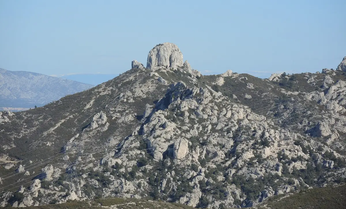 Le Pilon du Roi, rocher calcaire qui domine Simiane-Collongue, au sommet d'une crête du massif de l'Étoile, sous un ciel bleu.